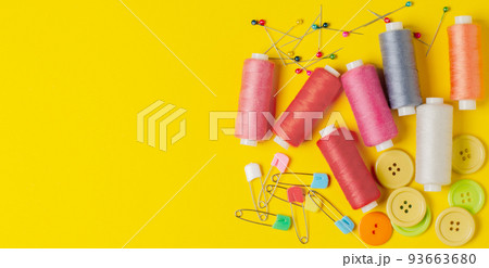 Sewing accessories on a yellow background. Closeup. Copy space 93663680