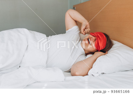 Beautiful happy redhead woman waking up in her bed, smiling and stretching, copy space. Millennial Caucasian girl stretch wake up in cozy white bed at home 93665166