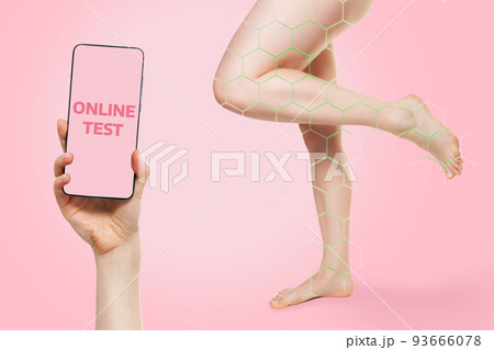 Beautiful healthy legs of a woman with a green zone for determining the disease. Smartphone for online health test. Mock up. Pink background. The concept of varicose veins and modern treatment 93666078
