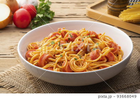 Hot dog or sausage stuffed with spaghetti in tomato pork sauce in white plate Hot dog or sausage stuffed with spaghetti in tomato pork sauce in white plate 93668049