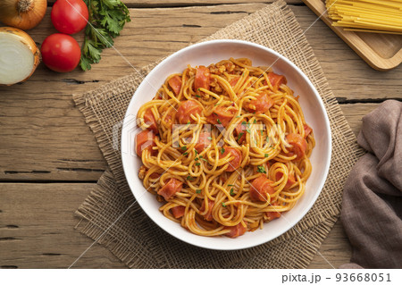Hot dog or sausage stuffed with spaghetti in tomato pork sauce in white plate.Top view Hot dog or sausage stuffed with spaghetti in tomato pork sauce in white plate.Top view 93668051