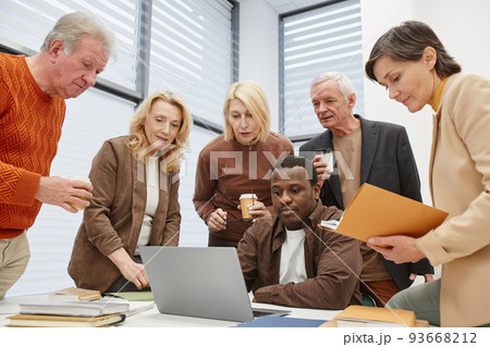 People learning to use laptop with teacher People learning to use laptop with teacher 93668212