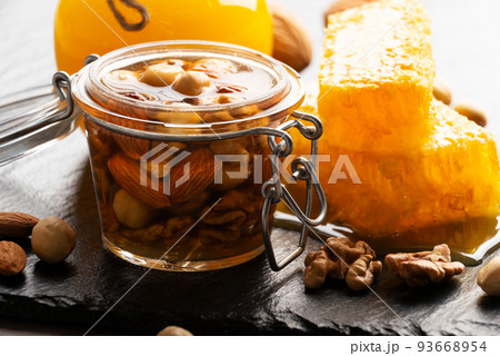 Honeyed assorted nuts in mason jar organic food background 93668954