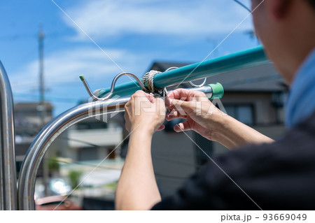 洗濯竿の固定をする男性 93669049