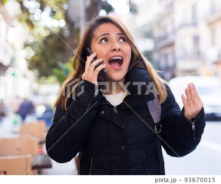 Angry young Latina shouting in mobile phone outdoors Angry young Latina shouting in mobile phone outdoors 93670015