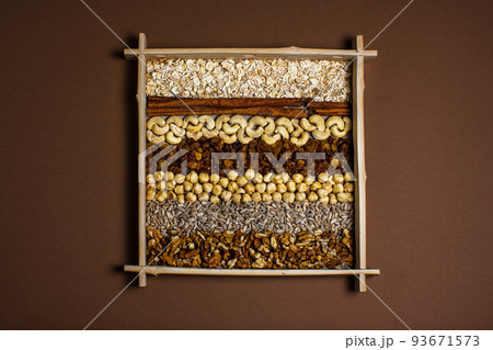 Rows of raw organic nuts and oatmeal for granola in box Rows of raw organic nuts and oatmeal for granola in box 93671573