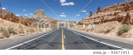 Scenic Road in the Dry Desert with Red Rocky Mountains in Background 93671951