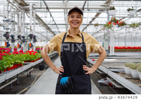 Happy woman florist in greenhouse Happy woman florist in greenhouse 93674429
