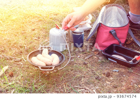 Traveler foods for outdoor activities. Camping food making in trip. Sausages in pot in the forest in sunny day. Traveler foods for outdoor activities. Camping food making in trip. Sausages in pot in the forest in sunny day. 93674574