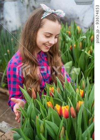 tulip flowerbed. gardening activity for kid. happy teen girl florist in greenhouse. 93674653