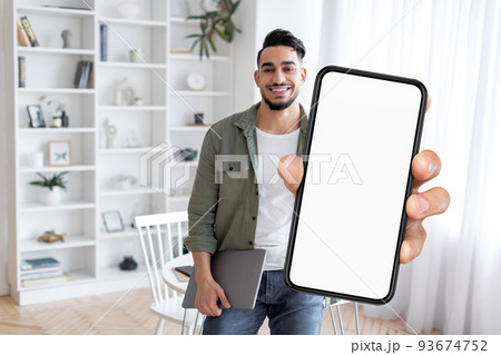 Online Ad. Smiling Arab Man Demonstrating Smartphone With Big Blank Screen 93674752