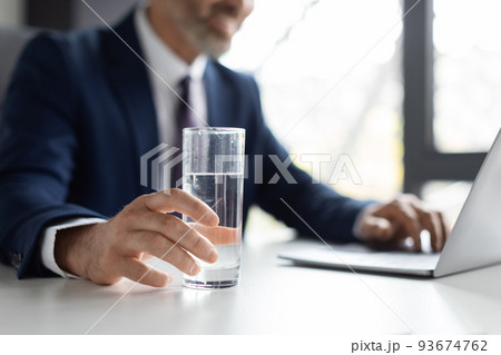 Unrecognizable Middle Aged Businessman Holding Glass Of Water While Sitting In Office 93674762