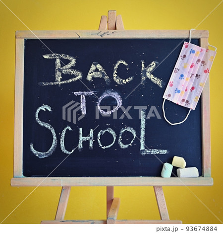 Blackboard - back to school. Concept for education and school on yellow background. With a mask to protect against covid 19. 93674884