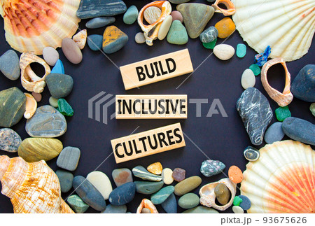 Build inclusive cultures symbol. Concept words Build inclusive cultures on wooden blocks. Beautiful black background. Sea stones and sea shells. Business build inclusive cultures concept. Copy space. Build inclusive cultures symbol. Concept words Build inclusive cultures on wooden blocks. Beautiful black background. Sea stones and sea shells. Business build inclusive cultures concept. Copy space. 93675626