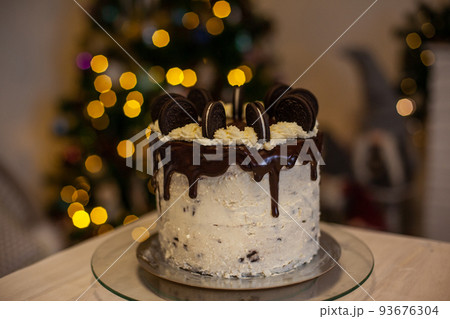 Cake with black cookies and with defocused christmas tree background 93676304