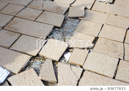 Cracked brown tiles on cement floor Cracked brown tiles on cement floor 93677655