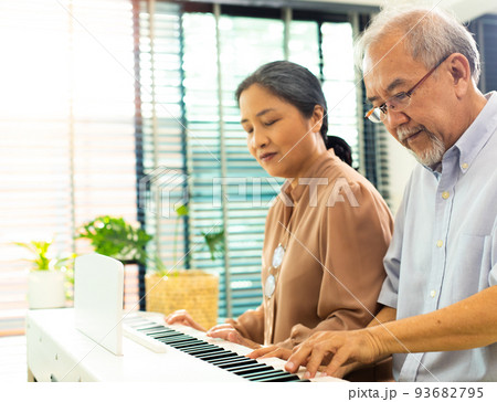 Elderly senior couple play Piano music together. Group of Two Asian smart mature Person retire and get pension fund. Grandparent express feeling happy treatment. Concept grow old together, copy space Elderly senior couple play Piano music together. Group of Two Asian smart mature Person retire and get pension fund. Grandparent express feeling happy treatment. Concept grow old together, copy space 93682795