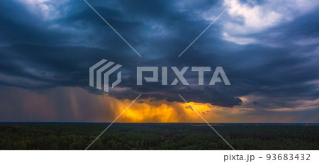 Storm cloud in the sunset light, aerial drone panorama of a storm Storm cloud in the sunset light, aerial drone panorama of a storm 93683432