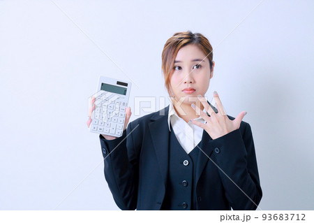 右手に電卓を持ち遠くを見つめる女性社員 93683712