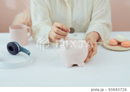 plan finance and savings money.young women put money coin in piggybank and calculate cost. plan finance and savings money.young women put money coin in piggybank and calculate cost. 93683726