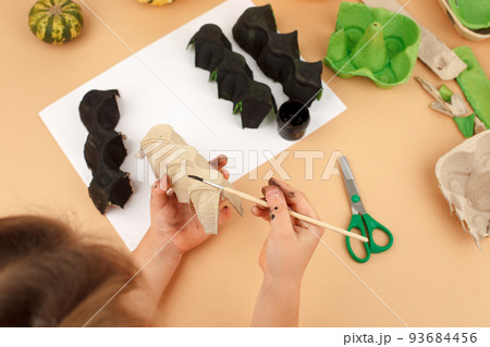 Diy Halloween decor from egg box beige background. Gift idea, home party decor Halloween. Instruction. Step by step, Top view. Children Halloween zero waste craft. Workshop. Step 3 Diy Halloween decor from egg box beige background. Gift idea, home party decor Halloween. Instruction. Step by step, Top view. Children Halloween zero waste craft. Workshop. Step 3 93684456