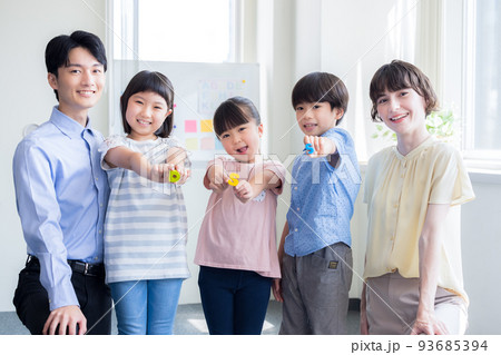 教育　英会話教室でレッスンを受ける子供と講師のポートレート 93685394