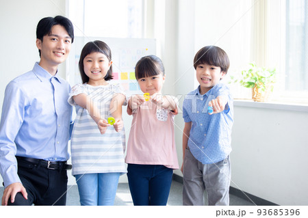 教育　英会話教室でレッスンを受ける子供と講師のポートレート 93685396