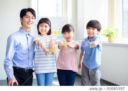 教育　英会話教室でレッスンを受ける子供と講師のポートレート 93685397