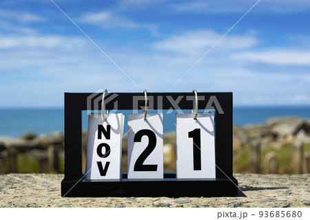 Nov 21 calendar date text on wooden frame with blurred background of ocean. Nov 21 calendar date text on wooden frame with blurred background of ocean. 93685680