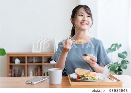 朝食を食べる女性 93686648