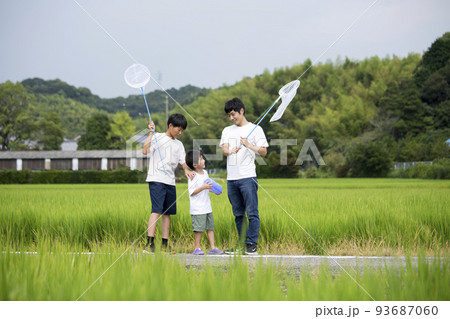 夏休み　帰省先の田舎で昆虫採取する親子　田んぼのあぜ道で撮影　トンボ採り 93687060
