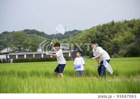 夏休み　帰省先の田舎で昆虫採取する親子　田んぼのあぜ道で撮影　トンボ採り 93687063