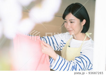 ダンボールに衣類を仕舞う女性 ダンボールに衣類を仕舞う女性 93687265