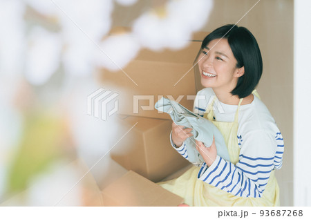 ダンボールに衣類を仕舞う女性 ダンボールに衣類を仕舞う女性 93687268