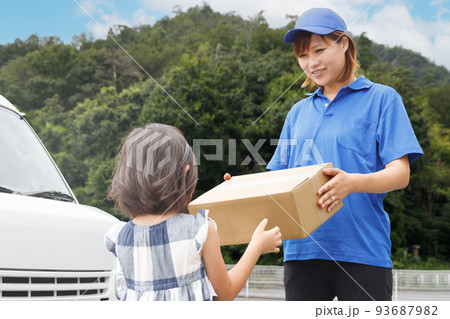 宅配をしている女性が子供に荷物を渡す。子供向け食材の宅配サービス業イメージ。 宅配をしている女性が子供に荷物を渡す。子供向け食材の宅配サービス業イメージ。 93687982