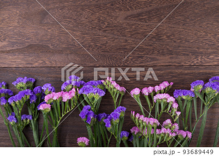 木のテーブルの上の並んだ二色のハナハマサジの花 93689449