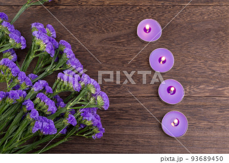 木のテーブルの上の紫のハナハマサジの花とキャンドル 木のテーブルの上の紫のハナハマサジの花とキャンドル 93689450