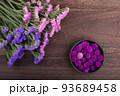 木のテーブルの上の二色のハナハマサジと千日紅の花 93689458