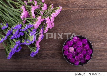 木のテーブルの上の二色のハナハマサジと千日紅の花 93689458