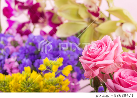 色々な花をバックにピンクのバラの花のアップ 93689471