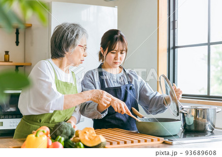 料理を見て文句を言う高齢者女性と泣く若い女性 93689608