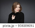 One young woman studio portrait wearing black turtleneck shirt. Image of young charming girl. One young woman studio portrait wearing black turtleneck shirt. Image of young charming girl. 93689691