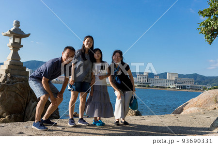夏の蒲郡の観光地竹島の海岸で記念撮影している家族四人の姿 93690331