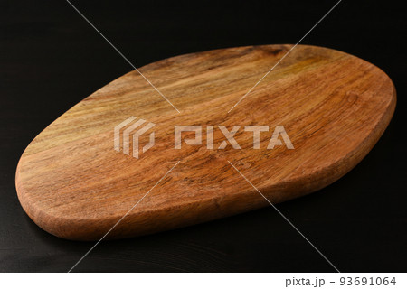 A wooden cutting board on a black table. Mock up. A wooden cutting board on a black table. Mock up. 93691064