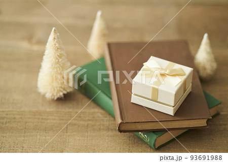 本の上に置かれたプレゼントボックスと卓上クリスマスツリー 93691988