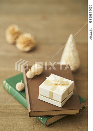 本の上に置かれたプレゼントボックスと卓上クリスマスツリー 本の上に置かれたプレゼントボックスと卓上クリスマスツリー 93692939