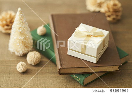 本の上に置かれたプレゼントボックスと卓上クリスマスツリー 本の上に置かれたプレゼントボックスと卓上クリスマスツリー 93692965
