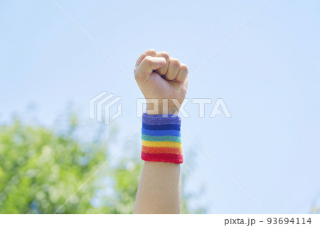 屋外で虹色のリストバンドをした男性の腕のクローズアップ 93694114