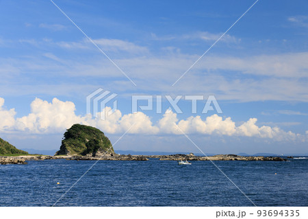 岬に沿って航行する小さなボート 93694335