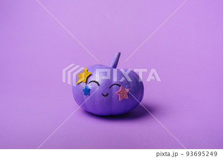 Beautiful purple pumpkin with a shiny disco make-up. Halloween holiday background concept 93695249